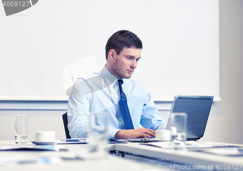 Image of businessman with laptop working in office