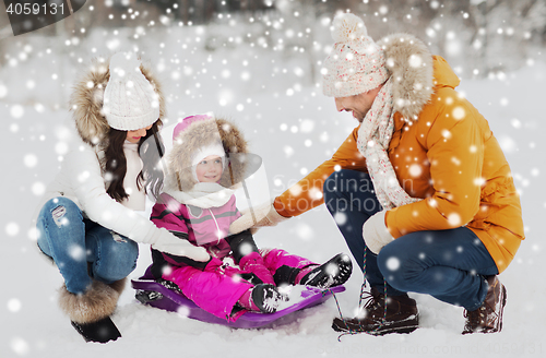 Image of happy family with sled walking in winter forest