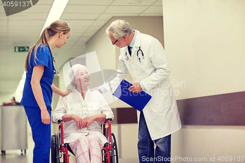 Image of medics and senior woman in wheelchair at hospital