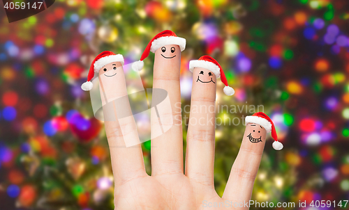 Image of close up of hand with four fingers in santa hats