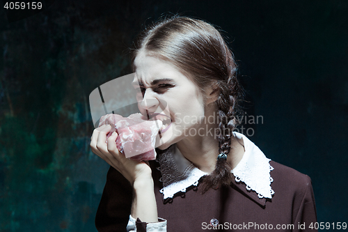 Image of Bloody Halloween theme: crazy girl with raw meat
