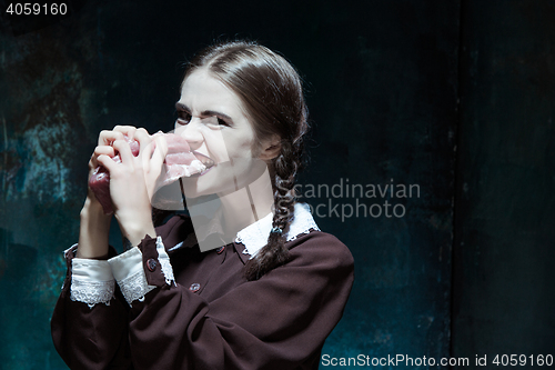 Image of Bloody Halloween theme: crazy girl with raw meat