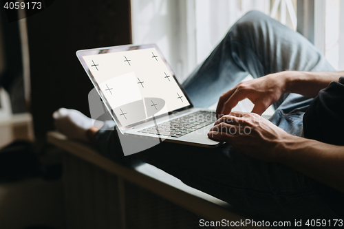 Image of Young man typing something on a laptop