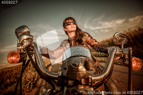 Image of Biker girl sitting on motorcycle