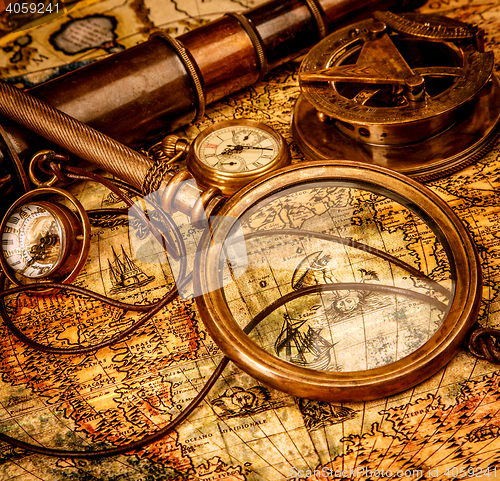 Image of Vintage magnifying glass lies on an ancient world map