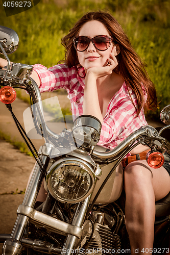 Image of Biker girl sitting on motorcycle