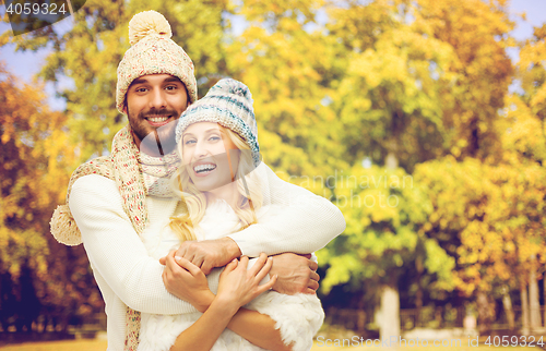 Image of happy couple in warm clothes over autumn