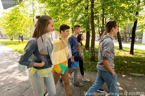 Image of group of happy teenage students walking outdoors