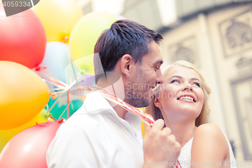 Image of happy couple with colorful balloons