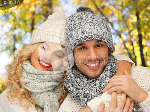 Image of happy couple in warm clothes over autumn