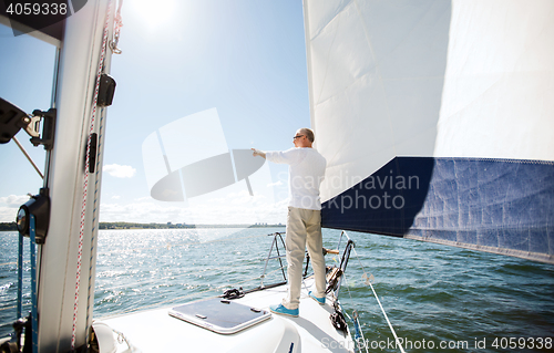 Image of senior man on sail boat or yacht sailing in sea