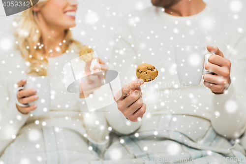 Image of close up of happy couple with cookies and tea cups