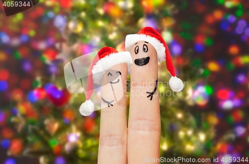 Image of close up of two fingers with smiley and santa hats