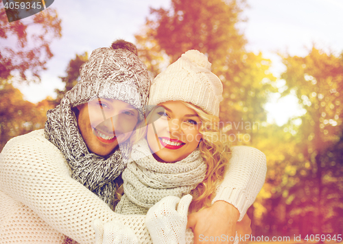 Image of happy couple in warm clothes over autumn