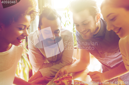 Image of happy business team eating pizza in office