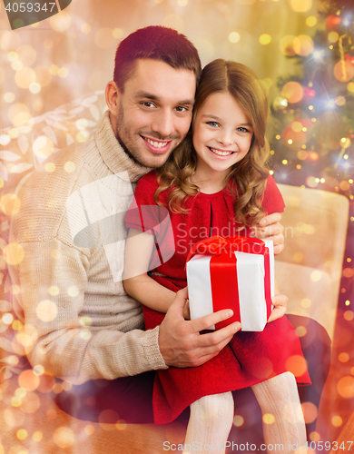 Image of smiling father and daughter holding gift box