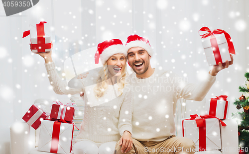 Image of happy couple at home with christmas gift boxes
