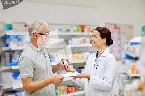 Image of pharmacist and senior man buying drug at pharmacy