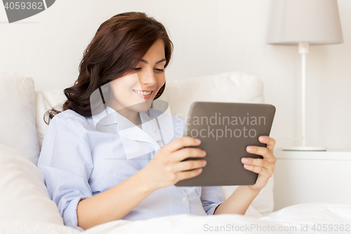 Image of happy pregnant woman with tablet pc at home