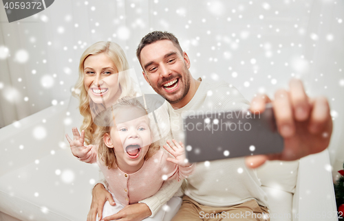 Image of family taking selfie with smartphone at home