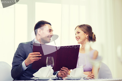 Image of smiling couple with menu at restaurant