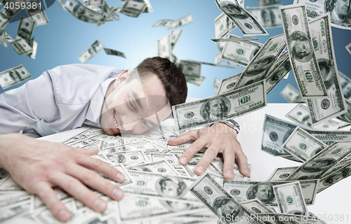 Image of happy businessman with heap of money