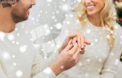 Image of man giving diamond ring to woman for christmas