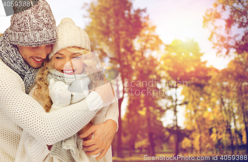 Image of happy couple in warm clothes over autumn