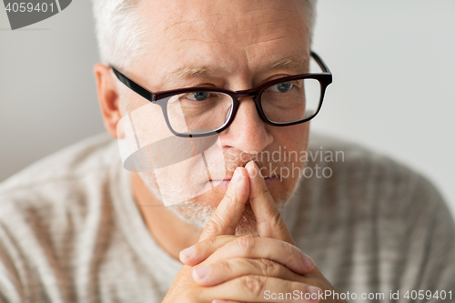 Image of close up of senior man in glasses thinking