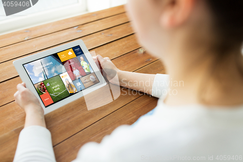 Image of close up of woman with tablet pc on wooden table