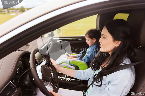 Image of happy woman with little child driving in car