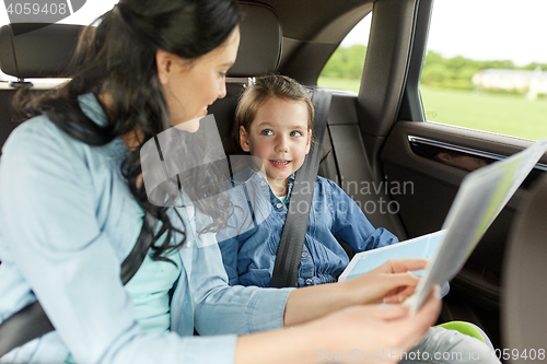 Image of happy family with travel map driving in car