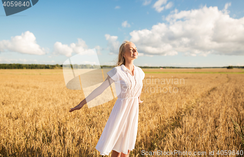 Image of smiling young woman in white dress on cereal field