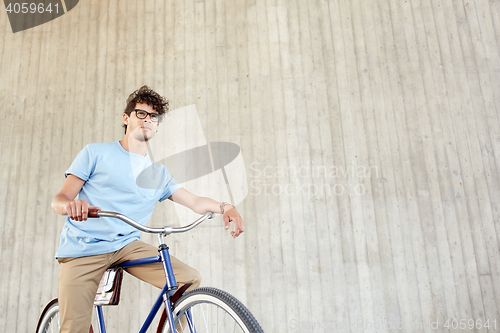 Image of young hipster man riding fixed gear bike