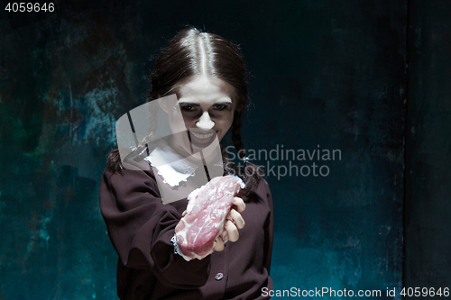 Image of Bloody Halloween theme: crazy girl with raw meat