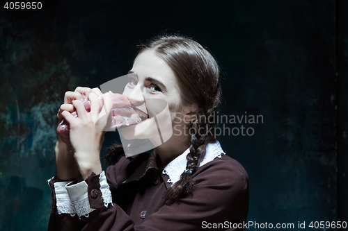 Image of Bloody Halloween theme: crazy girl with raw meat