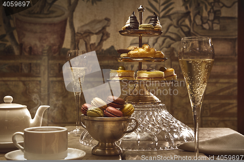 Image of luxury afternoon hot tea with champagne and macaroons