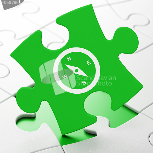Image of Vacation concept: Compass on puzzle background