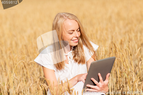 Image of happy young woman with tablet pc on cereal field