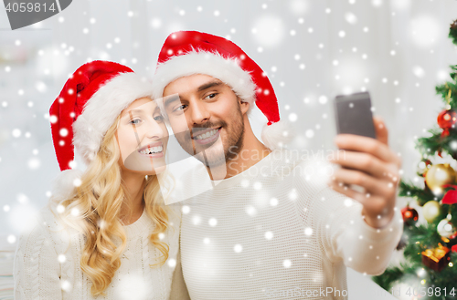 Image of couple taking selfie with smartphone at christmas