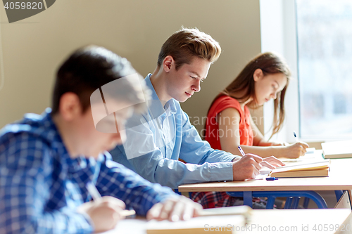 Image of group of students with books writing school test