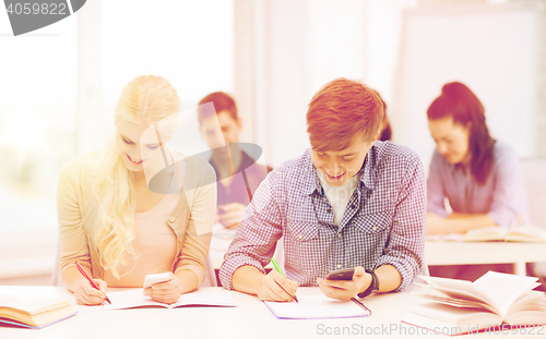 Image of students looking into smartphone at school