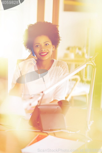 Image of businesswoman calling on smartphone at office