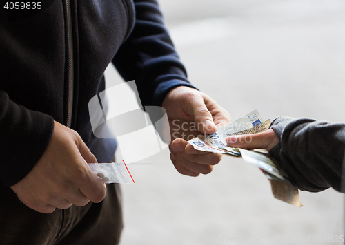 Image of close up of addict buying dose from drug dealer