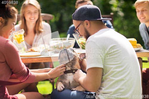 Image of happy friends having dinner at summer garden party