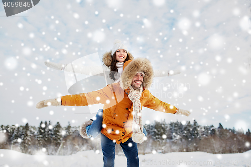 Image of happy couple having fun over winter background