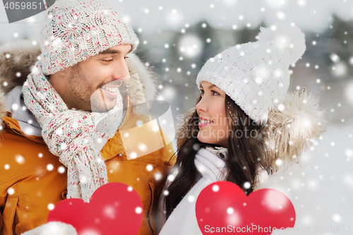 Image of happy couple with red hearts over winter landscape