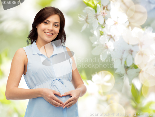 Image of happy pregnant woman making heart gesture on belly