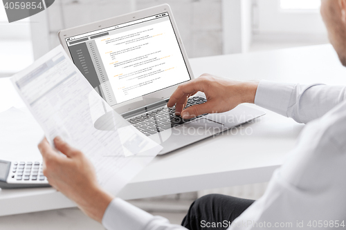 Image of businessman with laptop computer working at office