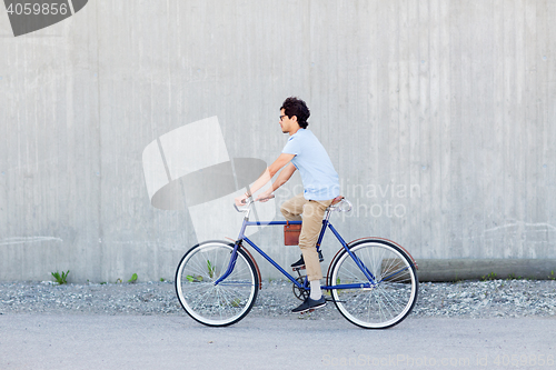 Image of young hipster man riding fixed gear bike